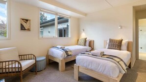 Ein Schlafzimmer mit zwei Einzelbetten, einem Schlafsofa und einem Fenster.