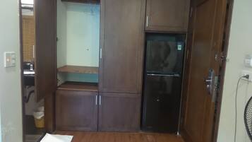 Uma cozinha compacta com geladeira, um armário de madeira e bancada.