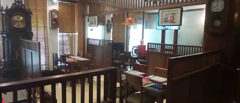 Un interior tradicional con muebles de madera, un reloj y obras de arte en las paredes.