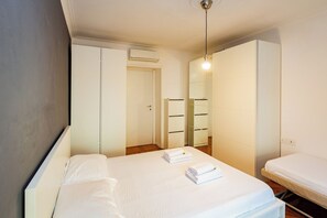 Ein Hotelzimmer mit einem Bett, einem Kleiderschrank, einem Spiegel und einer Pendelleuchte.