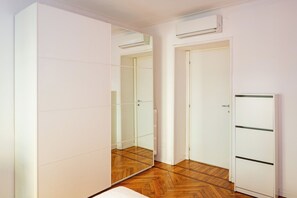 A room with a mirrored wardrobe, a radiator, and a door with a handle. - Buenosaires5 Elegance in Porta Venezia by Hospity (Milan)