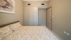 A bedroom with a bed, a wardrobe, and a door. - 2-bedroom apartment in peaceful Buiness Bay with fitness room and AC (Buiness Bay)