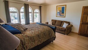 A bedroom with a large bed, a sofa, and a painting on the wall. - Uvae Vineyard by Avantstay Jetted Tubs + BBQ Patios Paso Wine Country (Paso Robles)