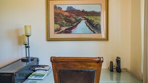 A desk with a lamp, a framed landscape painting, and a leather chair. - Uvae Vineyard by Avantstay Jetted Tubs + BBQ Patios Paso Wine Country (Paso Robles)