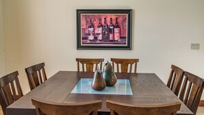 A dining table with six wooden chairs, a glass top, and two ceramic vases. - Uvae Vineyard by Avantstay Jetted Tubs + BBQ Patios Paso Wine Country (Paso Robles)