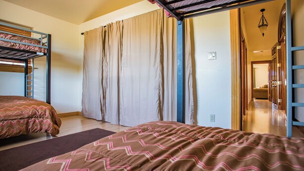 A room with bunk beds, a large window with curtains, and a hallway leading to another room. - Uvae Vineyard by Avantstay Jetted Tubs + BBQ Patios Paso Wine Country (Paso Robles)