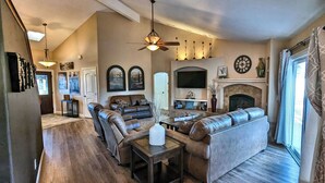 A spacious living room with a fireplace, leather sofas, a dining table, and a TV mounted on the wall. - Candlewood Creek by Avantstay Pool + Fire Pit Quiet Paso Cul-de-sac (Paso Robles)