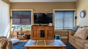 A living room with a television, wooden cabinet, and a couch. - Hope's Place by Avantstay Hilltop Views + Game Room Near Lake Nacimiento (Paso Robles)