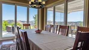 A dining area with a table set for six, overlooking a scenic landscape. - Hope's Place by Avantstay Hilltop Views + Game Room Near Lake Nacimiento (Paso Robles)