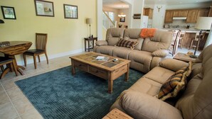 A living room with a sofa, coffee table, and dining area with chairs. - Navajo Trail by Avantstay Lap Pool + Spa Steps to Salinas River Trail (Paso Robles)