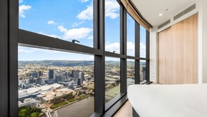 Ett modernt hotellrum med stora fönster som erbjuder utsikt över staden.