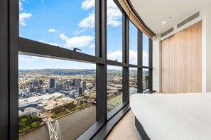 Ein modernes Hotelzimmer mit großen Fenstern und Blick auf die Stadt.