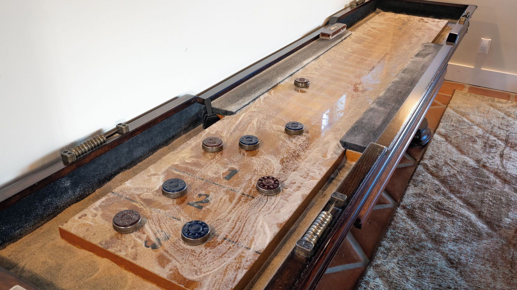 A pool table with numbered pockets and a cue stick.