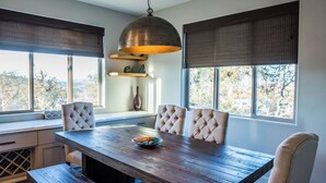 A dining area with a wooden table, cushioned chairs, and a pendant light. - Paso Dream by Avantstay Oak Views + Great Room Quiet Paso Cul-de-sac (Paso Robles)