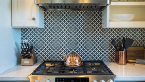 A kitchen with a gas stove, a kettle, and a knife block. - Paso Dream by Avantstay Oak Views + Great Room Quiet Paso Cul-de-sac (Paso Robles)