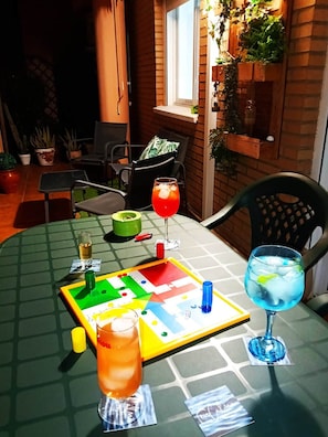 A table set for a game with a board game, drinks, and cards. - Encalma vacacional El Ático, terraza,garaje,playa (Port de Sagunt)