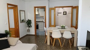 A compact living space with a dining area, kitchenette, and a sofa. - Encalma vacacional El Ático, terraza,garaje,playa (Port de Sagunt)