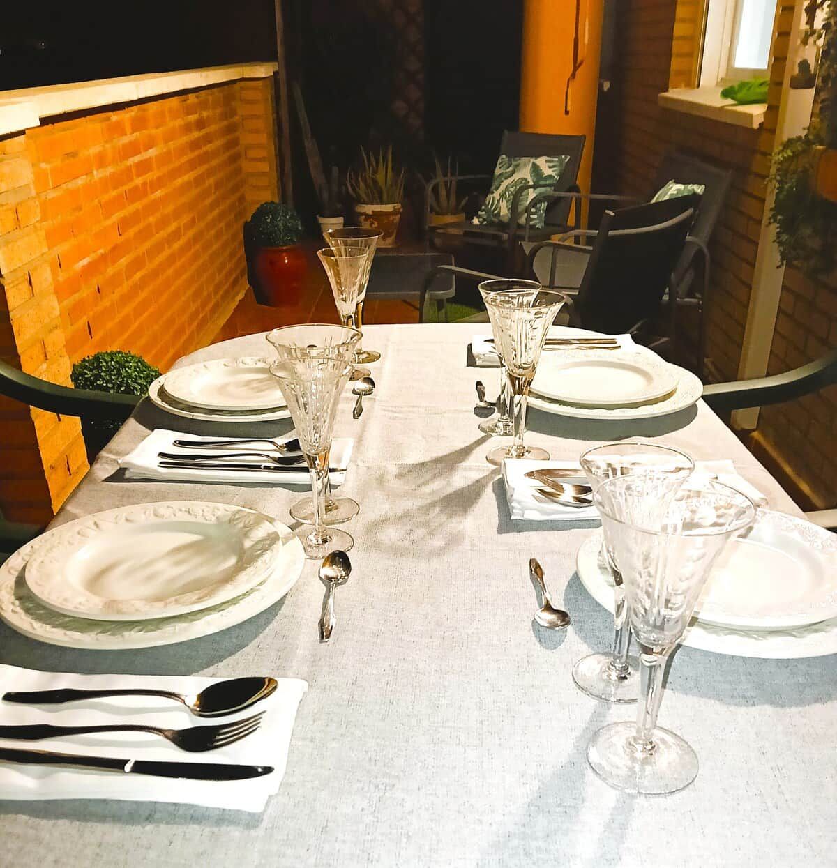A table set for a meal with plates, cutlery, and glasses.