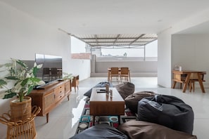 A modern living room with a sofa, coffee table, and a television on a wooden cabinet.