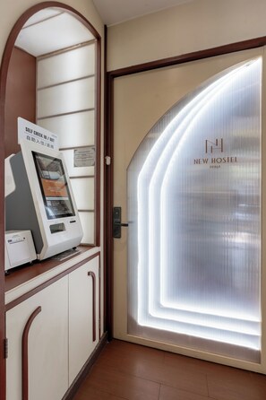 A self-check-in kiosk and a door to the New Hostel in Braga.