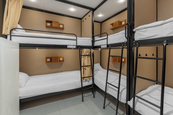 A bunk bed room with a wooden shelf and a curtain.