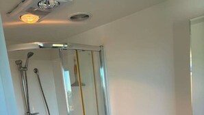 A modern bathroom with a glass-enclosed shower, a white toilet, and a sink. - Contempory Hillside studio in Cashmere (Christchurch)