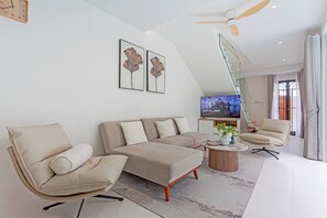A modern living room with a sectional sofa, a chaise lounge, a coffee table, and a television. - Modern Pool Villa Near Bangtoa Beach 5 Mins (Choeng Thale)