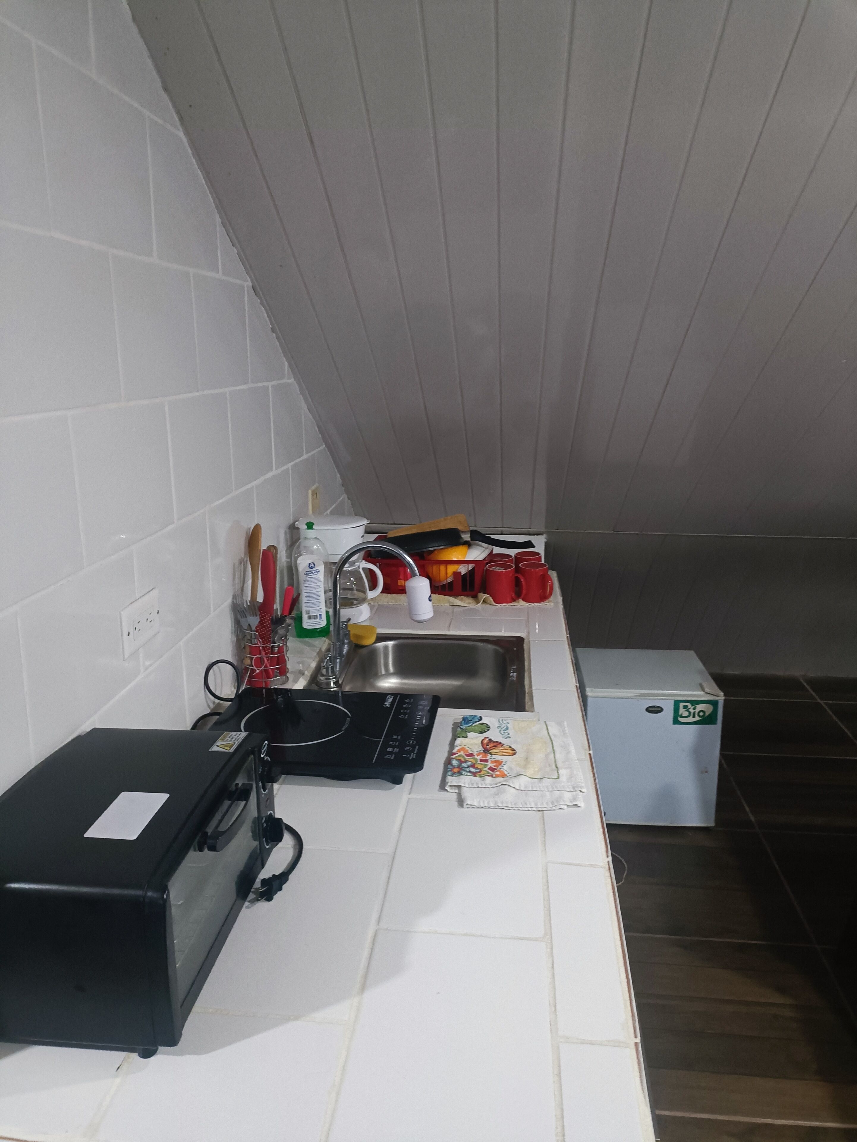 Eine Küche mit Mikrowelle, Spüle und kleinem Kühlschrank.