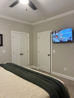 A bedroom with a bed, a television mounted on the wall, and a ceiling fan. - New Build! Modern Murfreesboro Townhome with Pool - 2BR/2.5BA - sleeps 6 (Murfreesboro)