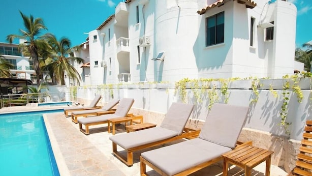 A poolside area with lounge chairs and a swimming pool. - Hotel Caribe Covenas (Tolú)