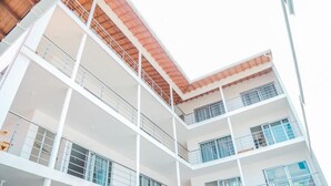 A multi-story building with balconies, large windows, and a modern architectural design. - Hotel Caribe Covenas (Tolú)