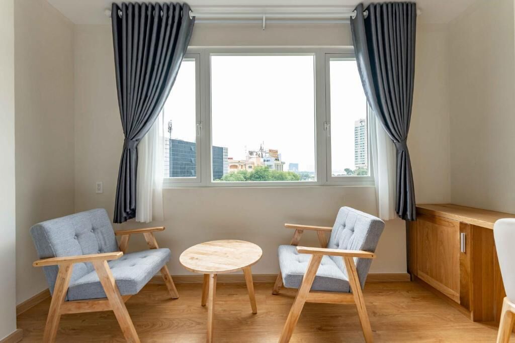 A room with two chairs, a small round table, and a wooden cabinet.