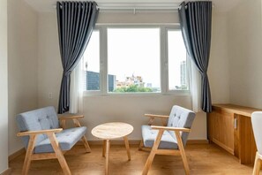 A room with two chairs, a small round table, and a wooden cabinet. - Edoya Hotel Dong Khoi (Ho Chi Minh Municipality)