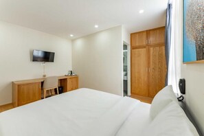 A hotel room with a bed, a desk, a TV, and a wardrobe. - Edoya Hotel Dong Khoi (Ho Chi Minh Municipality)
