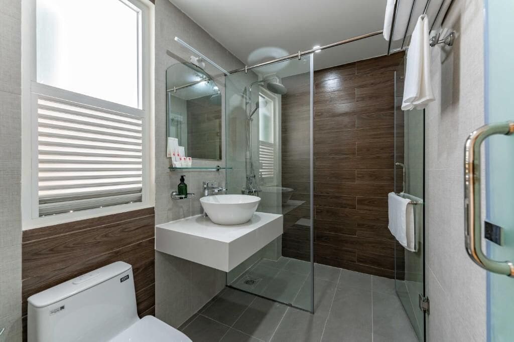 Une salle de bain moderne avec une douche à parois de verre, un lavabo blanc et des toilettes.
