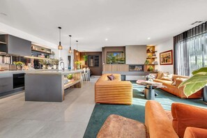 A modern living space with a kitchen, dining area, and seating area. - Coronation Station (Alpine)