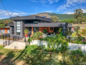 A modern two-story house with a flat roof, large windows, and a balcony. - Coronation Station (Alpine)