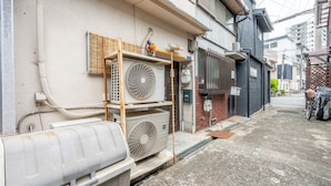 A narrow urban street with buildings, outdoor electrical equipment, and a bicycle. - Atlantis Tengachaya (Nishinari-ku, Osaka City)