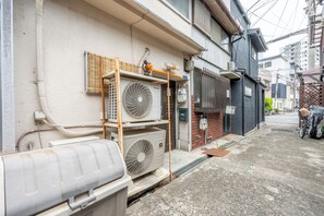 A narrow urban street with buildings, outdoor electrical equipment, and a bicycle. - Atlantis  Tengachaya (Nishinari-ku, Osaka City)