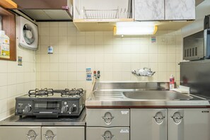 A kitchen with a gas stove, stainless steel sink, and cabinets. - Atlantis  Tengachaya (Nishinari-ku, Osaka City)