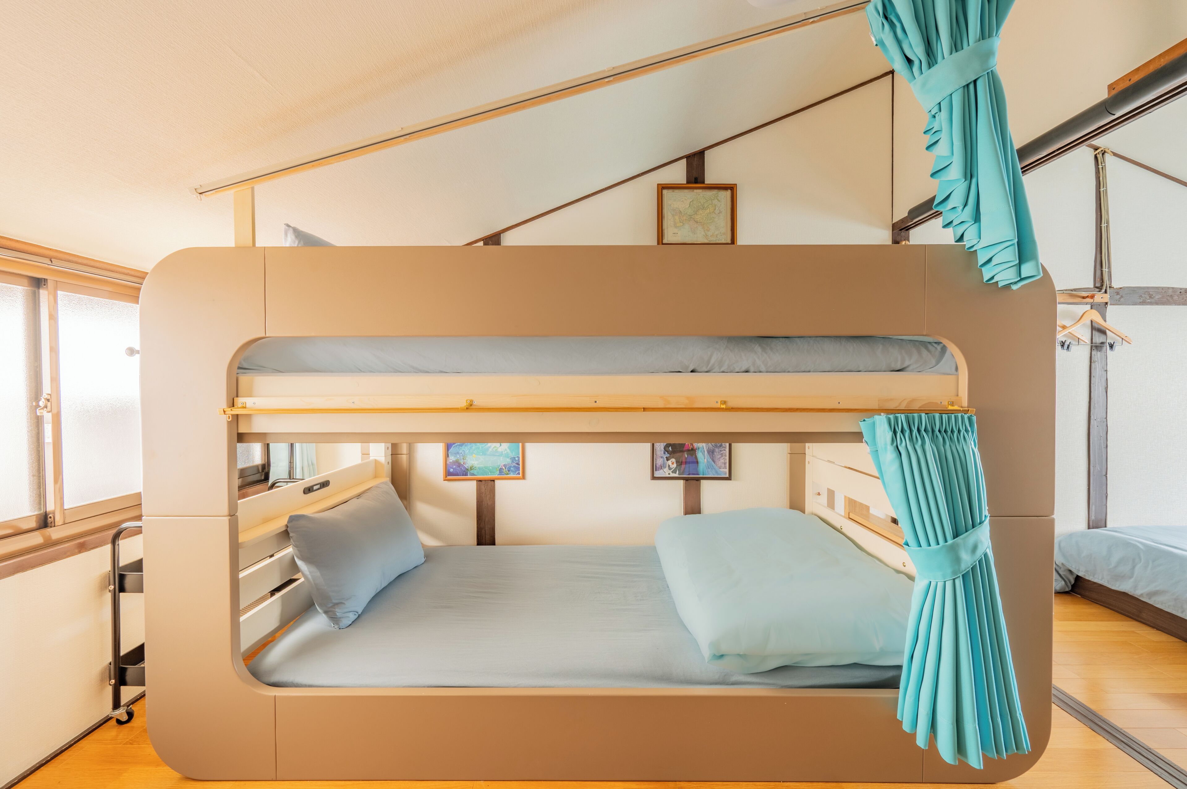 Un lit superposé avec une échelle escamotable, une petite fenêtre et un téléviseur fixé au mur.