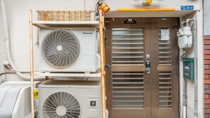Un equipo de aire acondicionado, una puerta con un letrero y un cuadro de empalmes.
