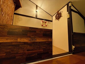 A hotel lobby with a wooden wall displaying street names, a life preserver hanging on the wall, and a ship's wheel decoration. - Atlantis  Tengachaya (Nishinari-ku, Osaka City)