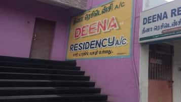 En bygning med et skilt for 'DEENA RESIDENCY A/C' og en trappe, der fører op til indgangen.