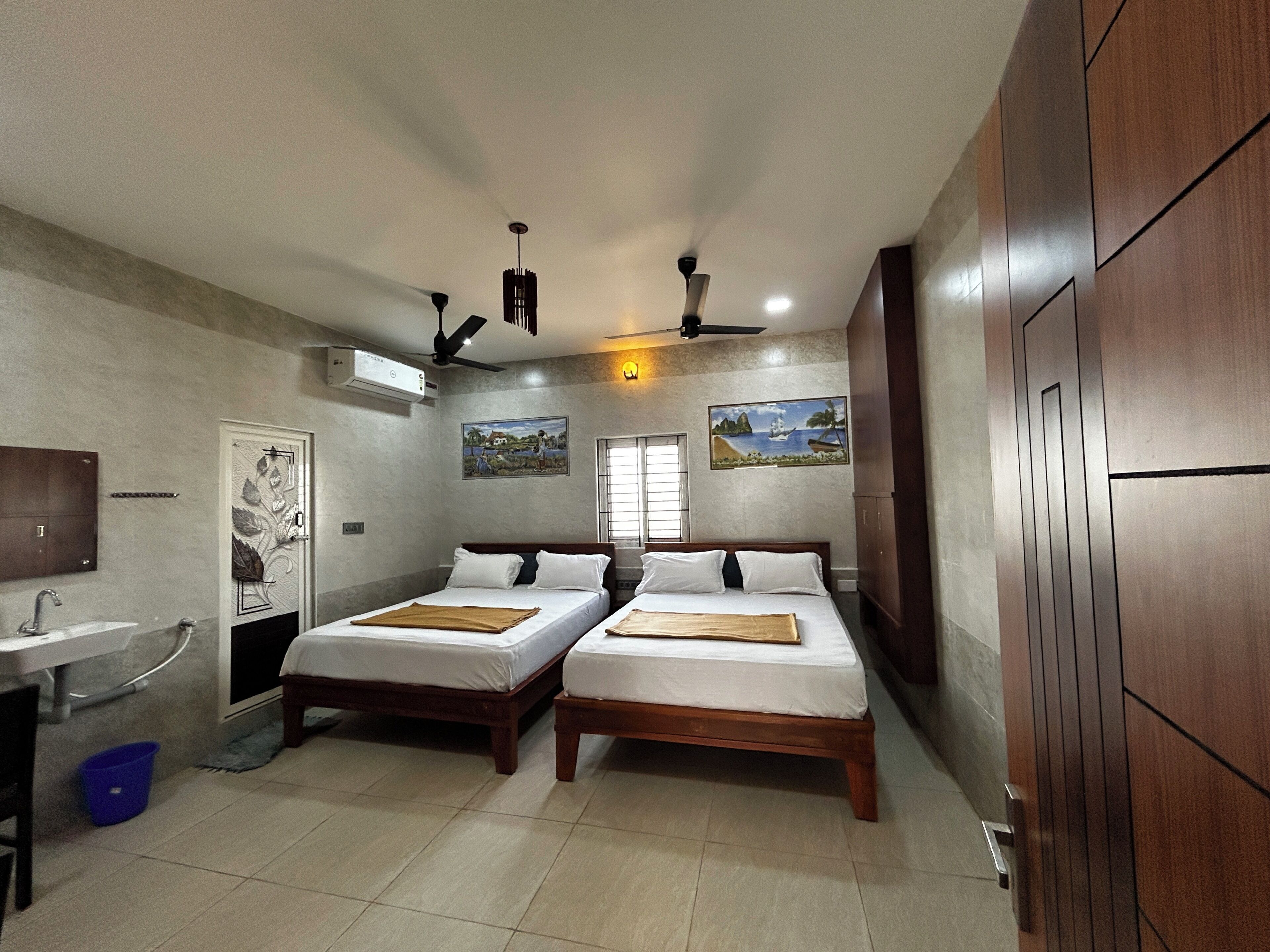 Une chambre d’hôtel avec deux lits, une salle de bain et vue sur la mer.