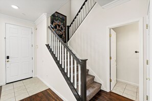 Eine Treppe mit Handlauf, Teppichstufen und einer Tür am oberen Ende.