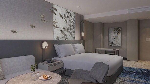 Et moderne hotelværelse med seng, sofa, skrivebord og stol.
