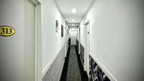 En hotelgang med døre nummereret 313, 314 og 315.