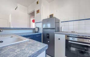 Eine Küche mit Spüle, Kühlschrank, Herd und Mikrowelle.