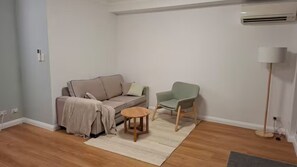 A living room with a sofa, a chair, a small table, and a floor lamp. - Modern & comfortable apartment in Redfern Central
2guests 1 bedroom 2 beds 1bath (Redfern)